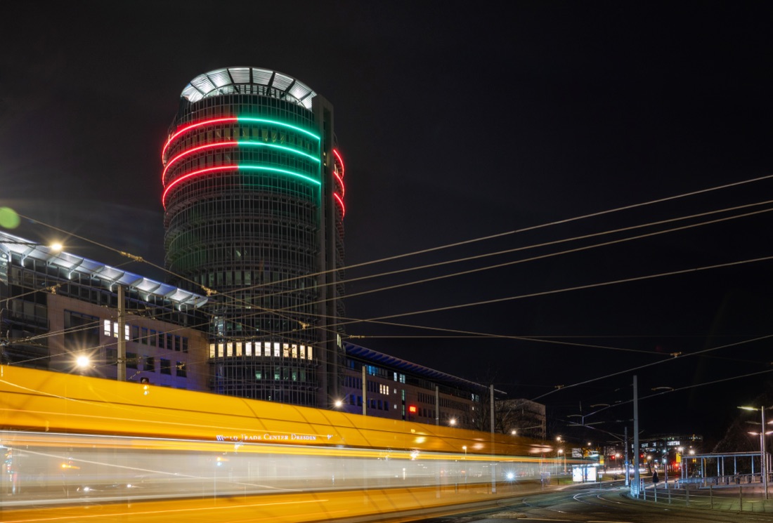 Das World Trade Center Dresden bei Nacht mit leuchtenden roten und grünen Lichtringen